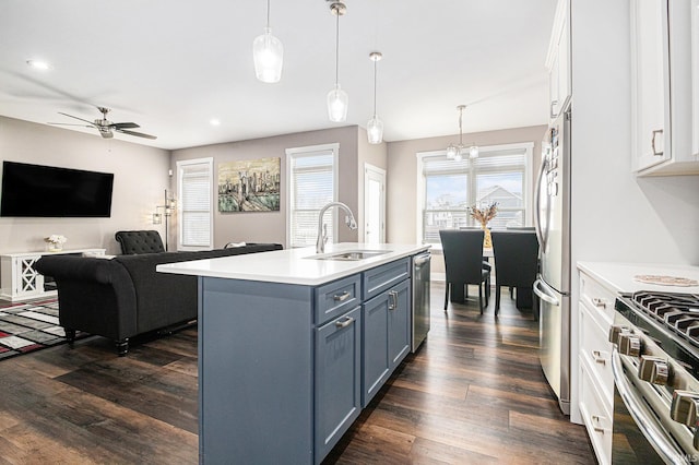 kitchen with white cabinets, stainless steel appliances, light countertops, and a sink