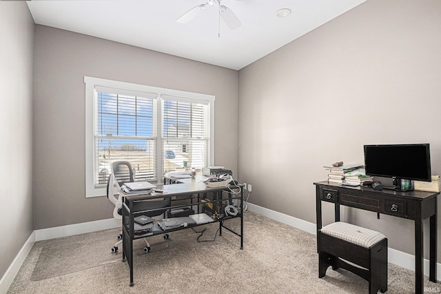 office space with baseboards, light colored carpet, and a ceiling fan