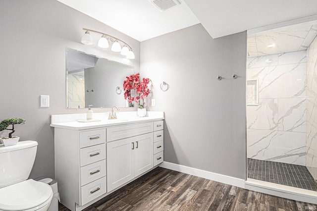 bathroom featuring a marble finish shower, visible vents, toilet, and wood finished floors