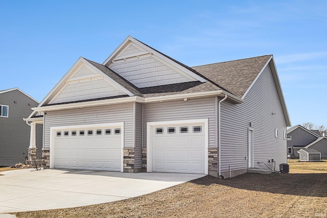 view of front of property featuring stone siding, concrete driveway, a garage, and a shingled roof