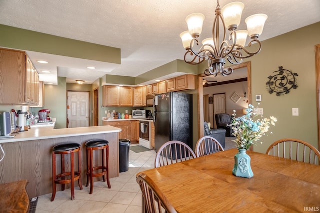 dining area with a toaster, a notable chandelier, light tile patterned floors, and a textured ceiling