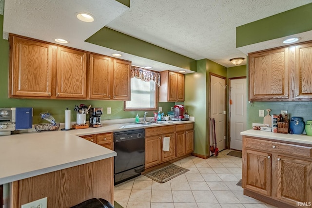 kitchen with dishwasher, light countertops, light tile patterned flooring, a textured ceiling, and a sink