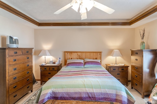 bedroom with baseboards, ceiling fan, light colored carpet, ornamental molding, and a raised ceiling