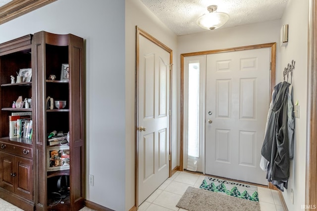 foyer entrance with light tile patterned floors and a textured ceiling