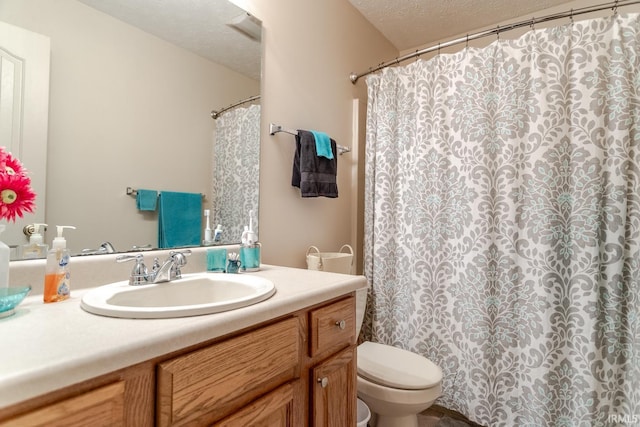 full bathroom with vanity, curtained shower, toilet, and a textured ceiling