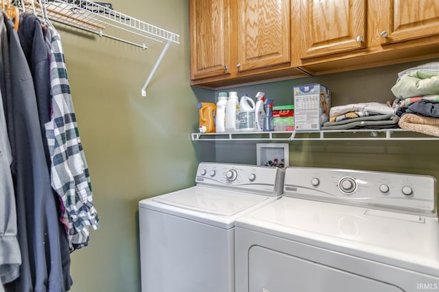 clothes washing area featuring cabinet space and washing machine and dryer