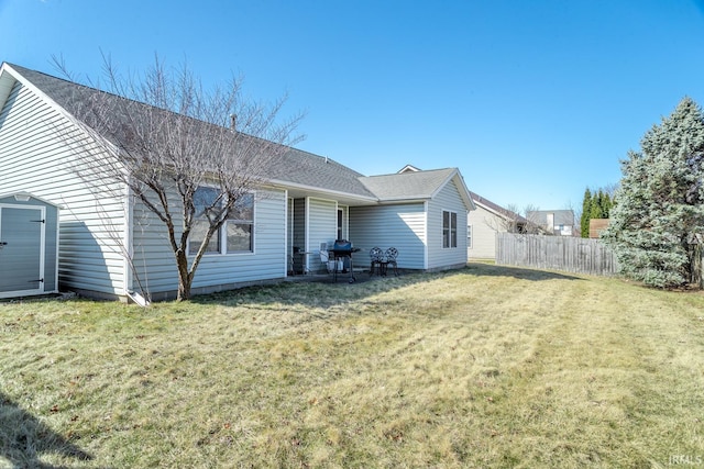 back of house with fence, a lawn, and roof with shingles