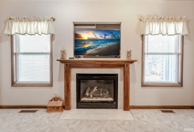 room details featuring a tiled fireplace, carpet flooring, baseboards, and visible vents