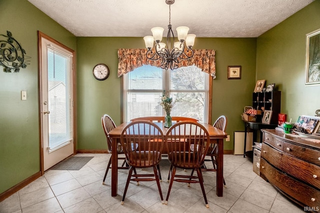 dining area with baseboards, a textured ceiling, an inviting chandelier, and light tile patterned flooring