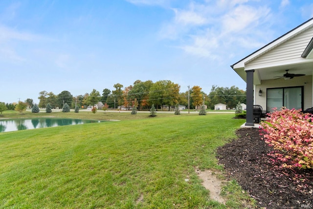 view of yard featuring a ceiling fan and a water view