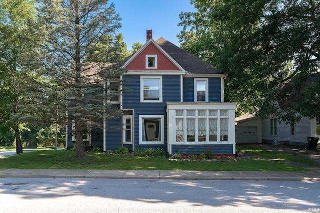 view of front of house featuring a front yard, a sunroom, and a chimney