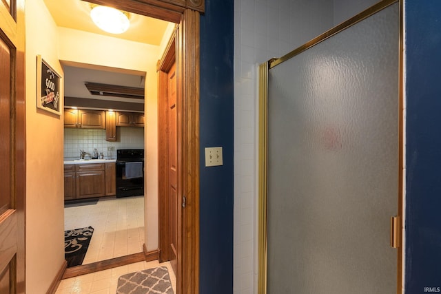 hall featuring a sink and light tile patterned flooring