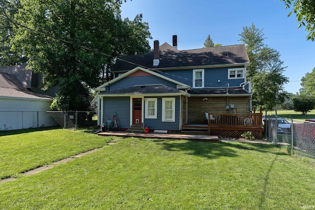 rear view of house featuring a deck, a fenced backyard, a lawn, and a chimney