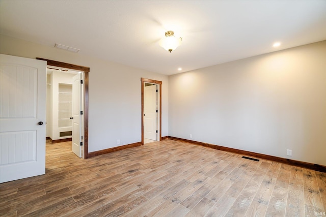 spare room with visible vents, recessed lighting, baseboards, and wood finished floors