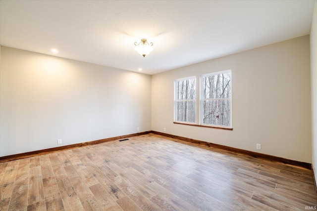 spare room featuring recessed lighting, visible vents, baseboards, and wood finished floors