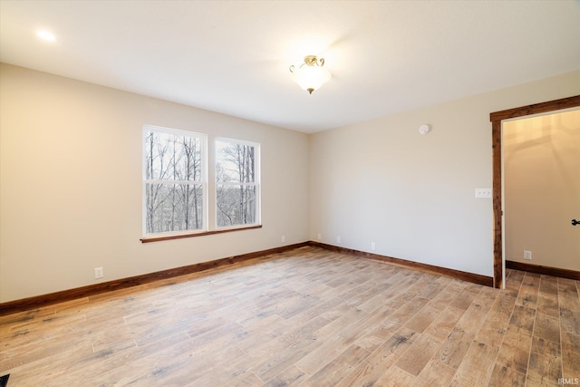 empty room featuring baseboards and light wood-style floors