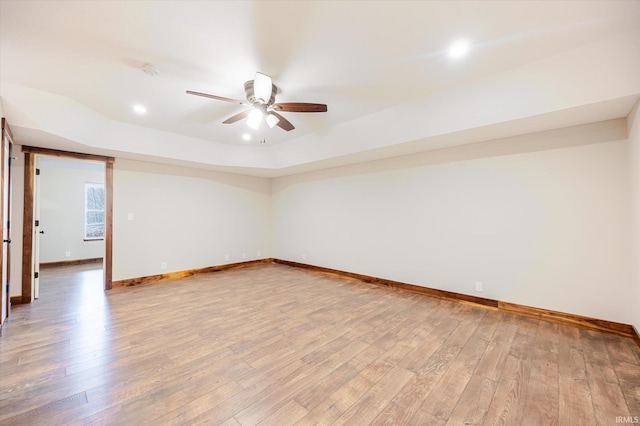 spare room featuring light wood finished floors, baseboards, and a ceiling fan