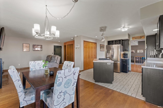 dining space with light wood finished floors, a chandelier, recessed lighting, and baseboards