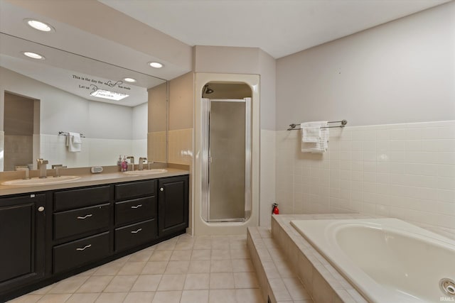 full bathroom featuring a bath, a stall shower, double vanity, and a sink