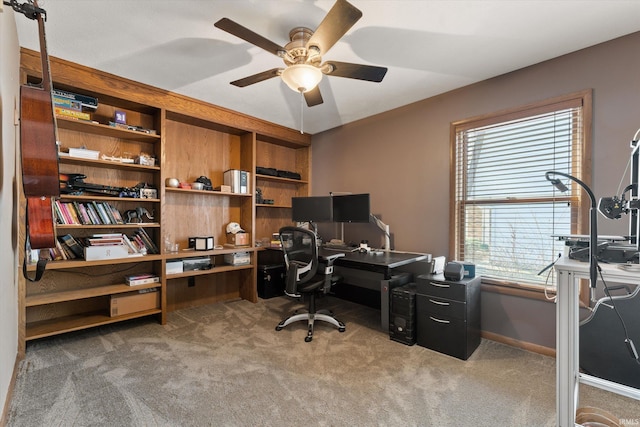 carpeted home office with a ceiling fan and baseboards