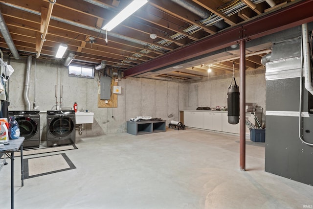 basement with a sink, electric panel, heating unit, and washing machine and clothes dryer