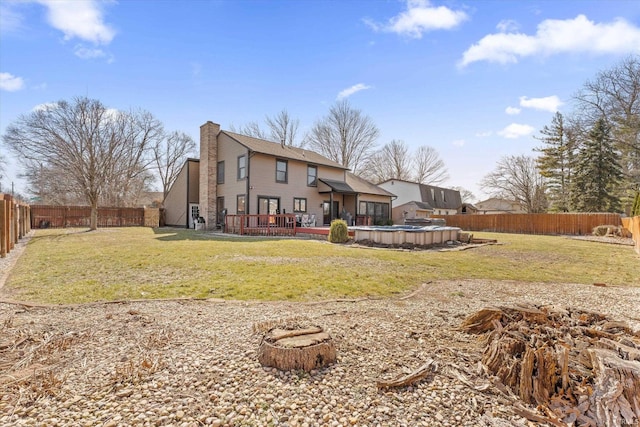 back of house featuring a lawn, a fenced backyard, a fenced in pool, and a chimney