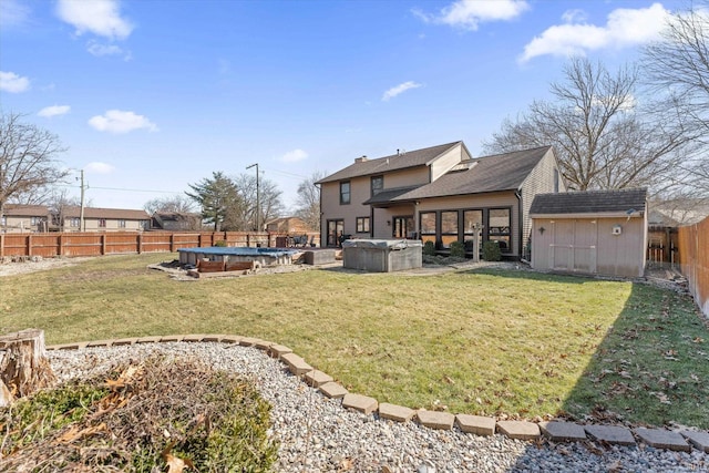 back of house featuring an outdoor structure, a yard, a fenced backyard, and a shed