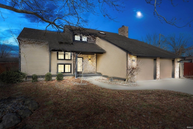 view of front of house with an attached garage, driveway, a chimney, and roof with shingles