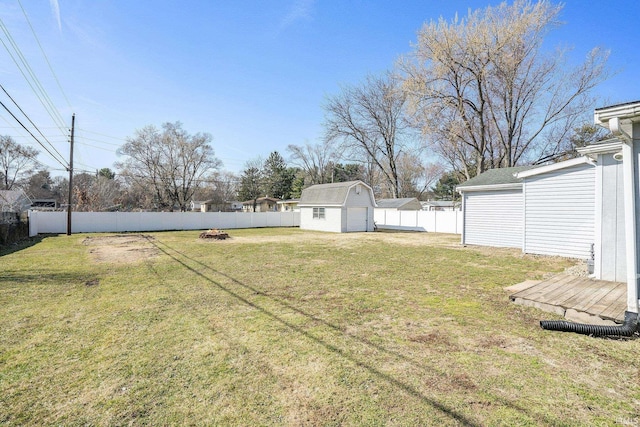 view of yard featuring an outbuilding, a storage unit, and a fenced backyard