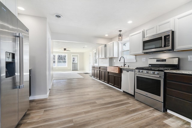 kitchen with visible vents, a ceiling fan, a sink, appliances with stainless steel finishes, and light wood finished floors