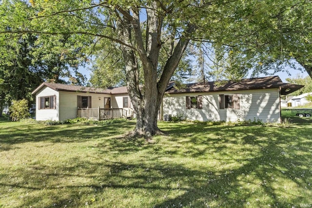 rear view of house featuring a deck and a yard