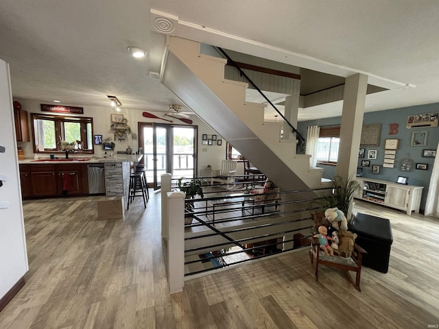 stairway with ceiling fan and wood finished floors