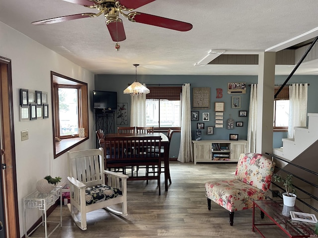 dining area with stairway, a textured ceiling, ceiling fan, and wood finished floors