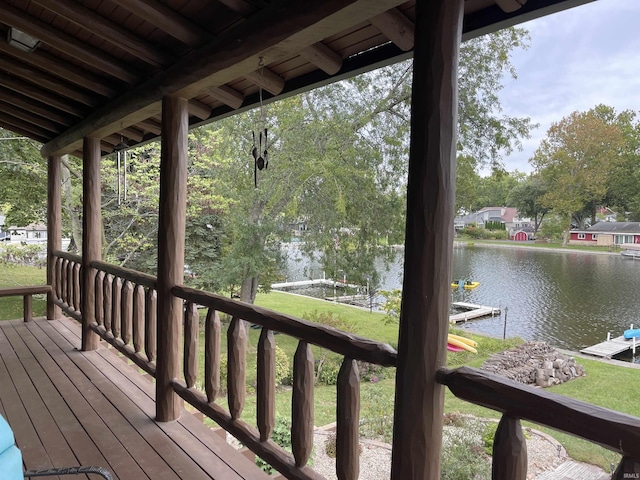 wooden deck with a dock and a water view