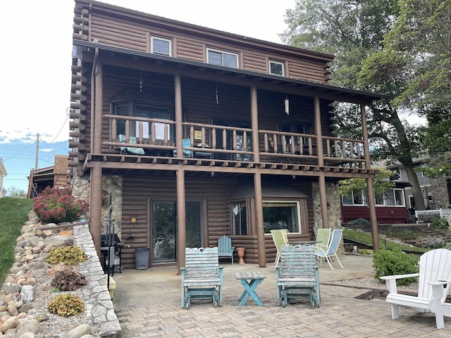 rear view of property with log exterior and a patio area