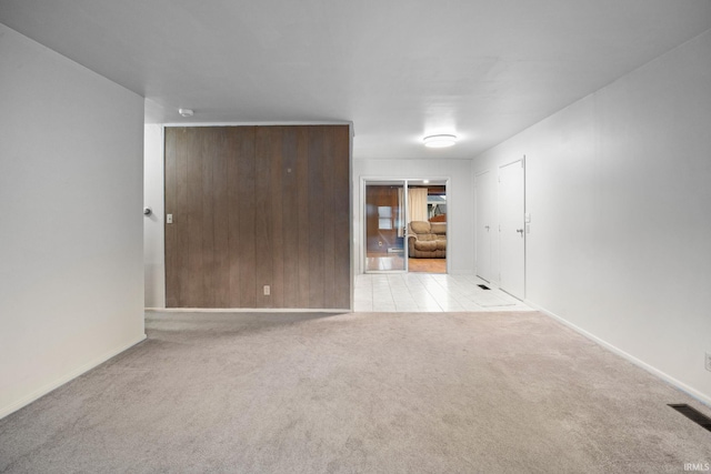 empty room with visible vents, light colored carpet, and baseboards