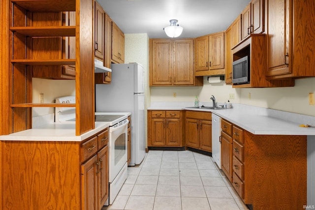 kitchen with a sink, light countertops, brown cabinetry, white appliances, and open shelves