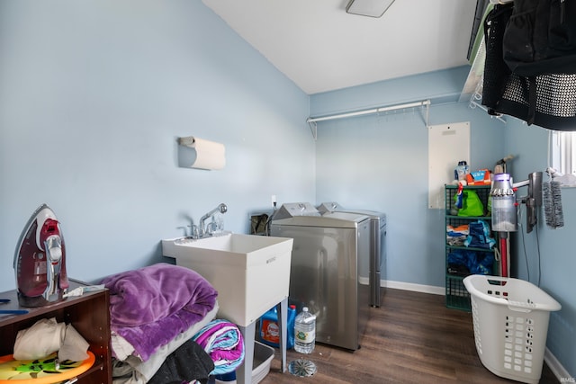 laundry room with a sink, wood finished floors, washing machine and dryer, baseboards, and laundry area