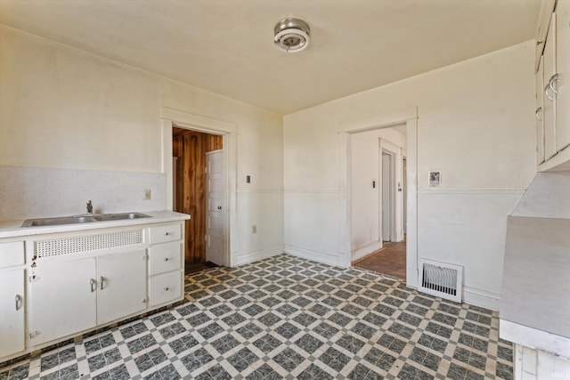 kitchen featuring a sink, visible vents, tile patterned floors, and light countertops