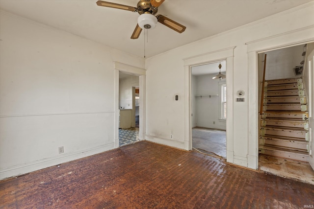 spare room featuring stairway, a ceiling fan, and wood finished floors