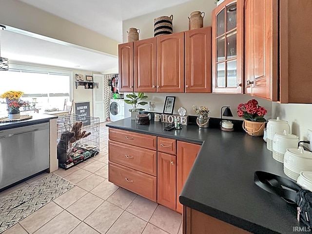 kitchen with light tile patterned floors, washer / clothes dryer, glass insert cabinets, dishwasher, and dark countertops