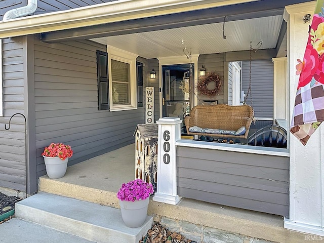 view of exterior entry featuring covered porch