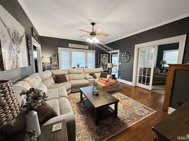 living room with baseboards, wood finished floors, ceiling fan, and crown molding