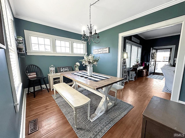 dining space featuring an inviting chandelier, plenty of natural light, wood finished floors, and visible vents