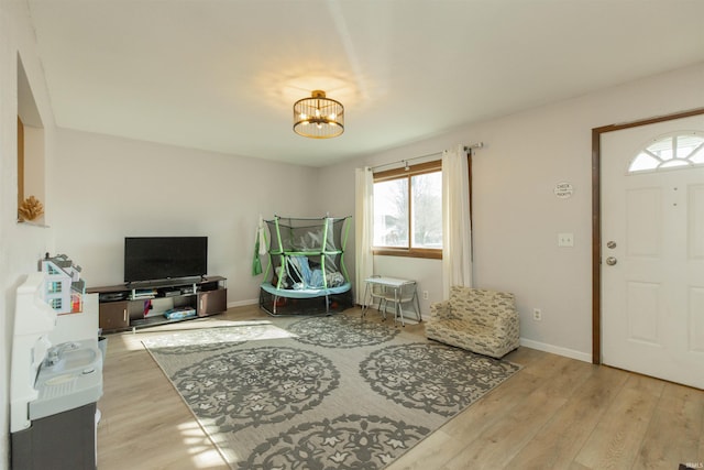 entryway featuring a chandelier, baseboards, and wood finished floors