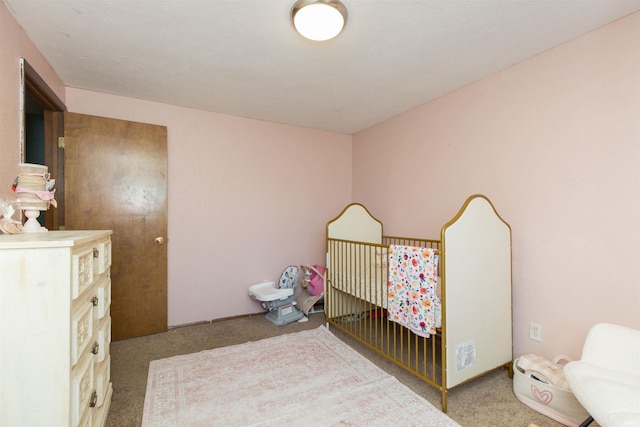 carpeted bedroom with a nursery area