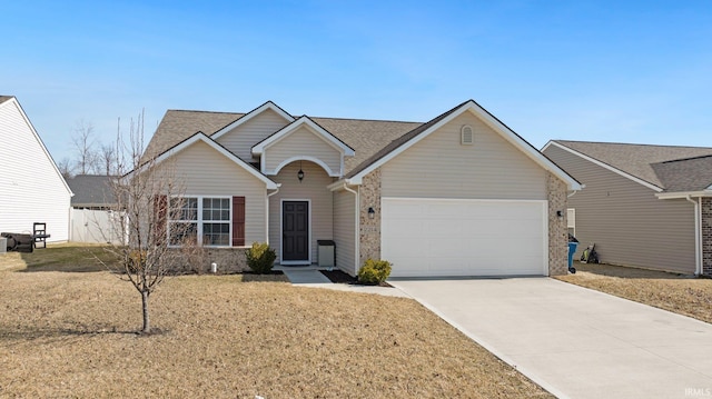 ranch-style house featuring concrete driveway, an attached garage, a front yard, and a shingled roof