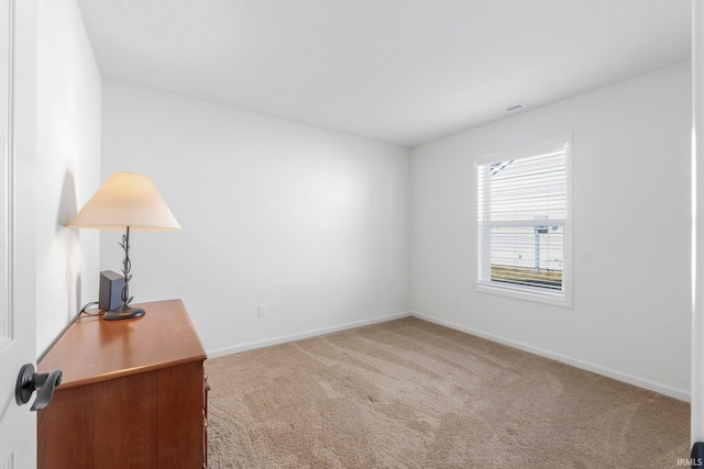 spare room featuring visible vents, baseboards, and carpet