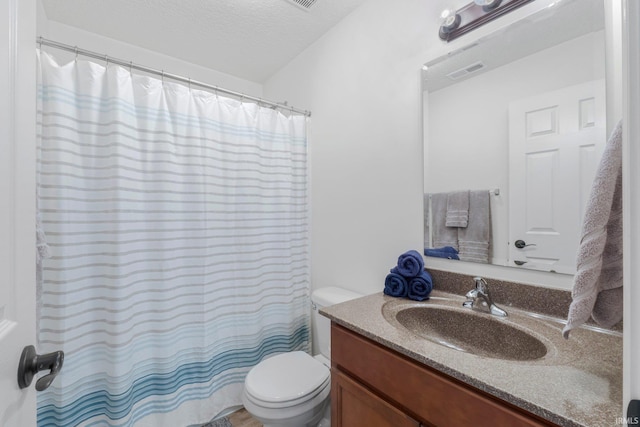 bathroom with visible vents, curtained shower, toilet, vanity, and a textured ceiling