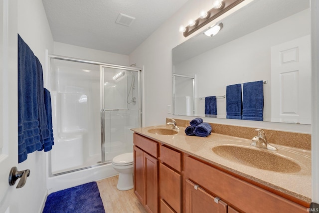 bathroom featuring visible vents, a stall shower, a textured ceiling, and a sink